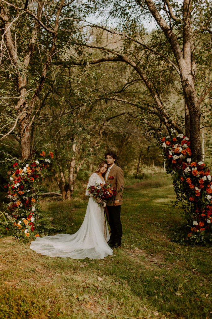 Couple eloping under two floral arches in the driftless region of Wisconsin