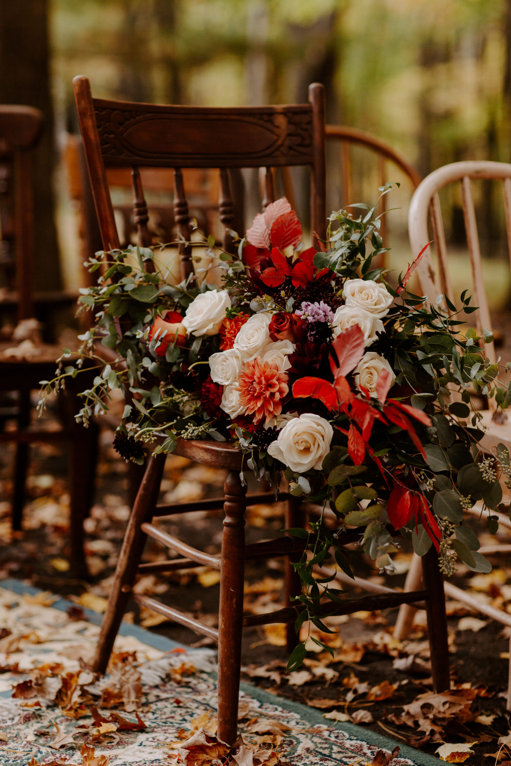 Bohemian fall wedding bouquet on a wooden chair for a backyard wedding in Eau Claire Wisconsin